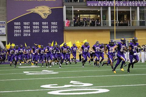 UNI's football team charging the field in the UNI-Dome.